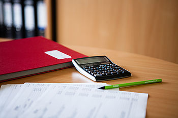 Notizbuch, Taschenrechner, Bleistift und eine Abrechnung © HTW Berlin