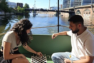 Zwei Personen spielen Schach während einer Bootsfahrt