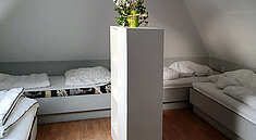 Blick in ein Schlafzimmer mit mehreren Betten