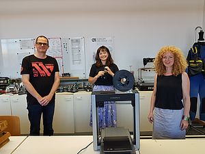 Drei Personen stehen im Labor. Vor ihnen ein 3D-Drucker. © HTW Berlin