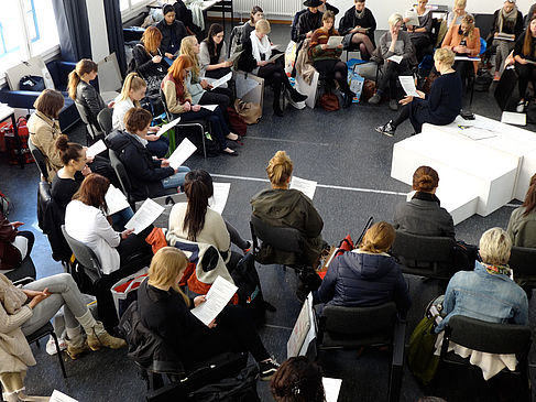 Viele Personen sitzen während einer Veranstaltung mit einem Papier in der Hand in einem Kreis © HTW Berlin