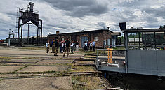 Eine Grupper Studierende am Bahnbetriebswerk Schöneweide bei einer Besichtigung.