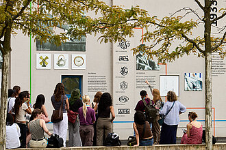 Eine Gruppe steht vor einer Outdoor Ausstellung