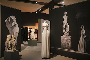 Weißes plissiertes Kleid am Eingang der Ausstellung © HTW Berlin/Alexander Rentsch